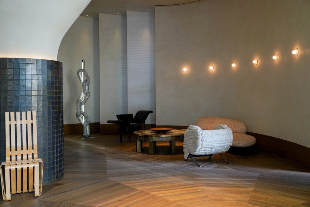 Curved plaster spa lounge at Santa Monica Proper with herringbone wood floor and warm wall sconces