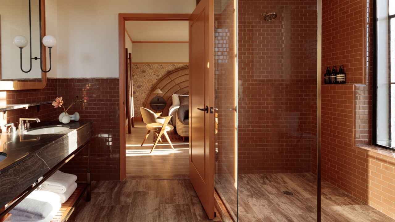 Terracotta-tiled bathroom and walk-in shower opening onto a Santa Monica Proper guestroom